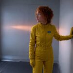 A clean, well-lit arrival bay with one entrance hatch and blank unbroken walls on every other side