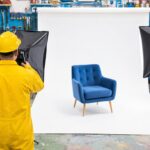 A pure white seamless product photography backdrop lit in the corner of a warm workshop