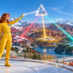 Crew member sends one beam of light through a prism that splits it into three colours, each lighting a different autumn valley