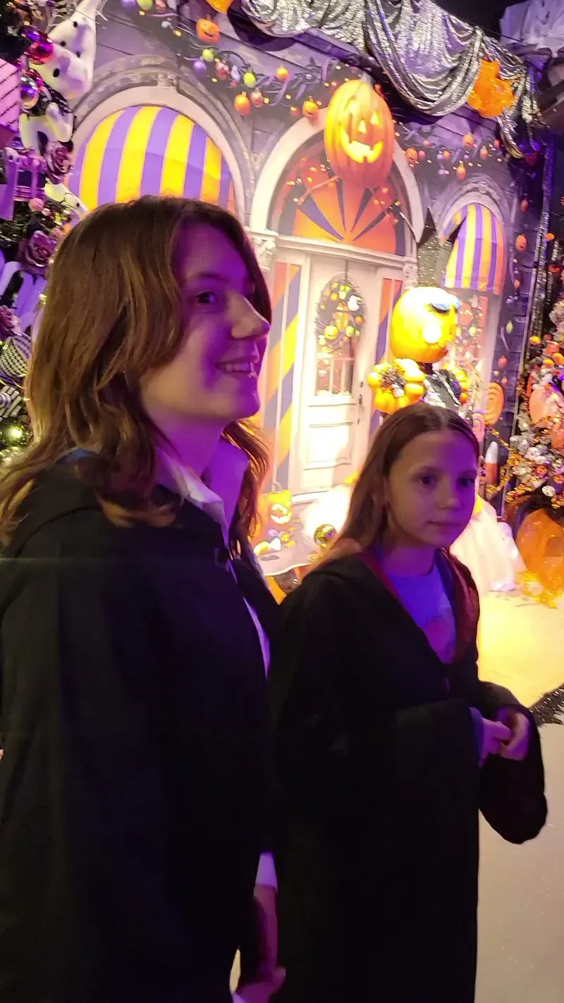 Two girls in witch costumes smiling inside Funtoria